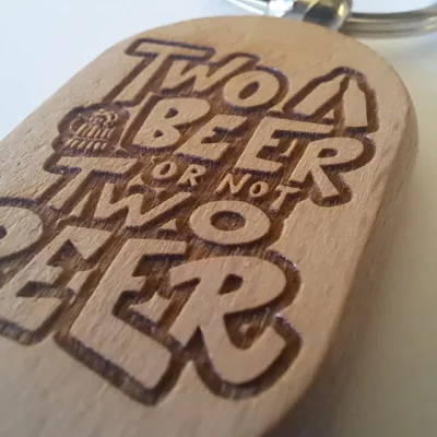 porte-cle-two-beer-humour-bois-detail.jpg Porte‑clé galet en bois clair – Personnalisable en ligne